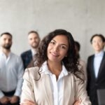 Woman Standing In Front Of Her Employees Posing In Office