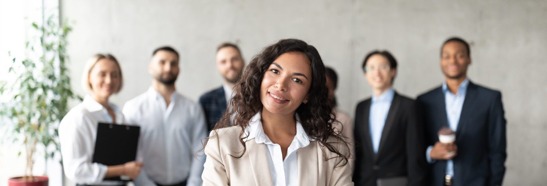 Woman Standing In Front Of Her Employees Posing In Office